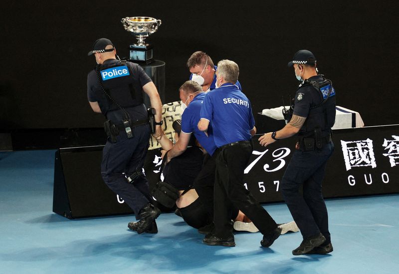 &copy; Reuters. اعتقال متظاهر من قبل الأمن بعد أن قفز إلى المحكمة أثناء المباراة النهائية في بطولة أستراليا المفتوحة في ملبورن يوم الاحد. تصوير: لورين إليوت