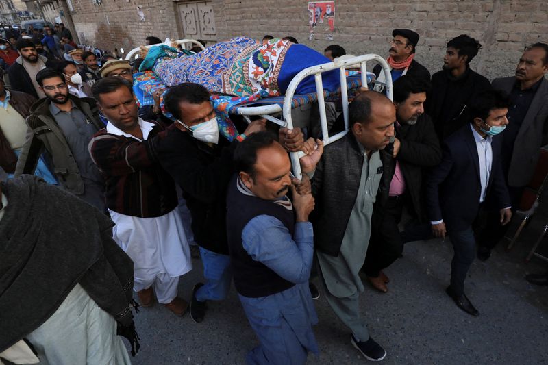 © Reuters. رجال يحملون جثمان القس وليام سراج الذي قتله مسحلون في بيشاور بباكستان يوم الأحد. تصوير:رويترز.