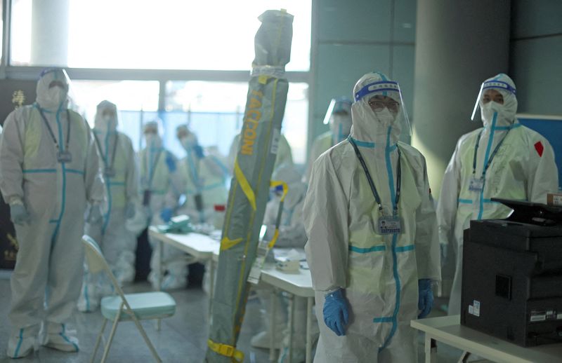 &copy; Reuters. Miembros del personal con equipo de protección personal (EPP) diseñado para prevenir la propagación de la enfermedad del coronavirus (COVID-19), esperan a los pasajeros en el Aeropuerto Internacional de Pekín Capital antes de los Juegos Olímpicos de 