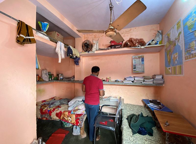 &copy; Reuters. Niranjan Kumar, one of the jobless youth protesting against alleged errors in Indian Railways recruitment, checks out a notebook in his dormitory room in Patna city in the eastern state of Bihar, India, January 29, 2022. Picture taken January 29, 2022. RE