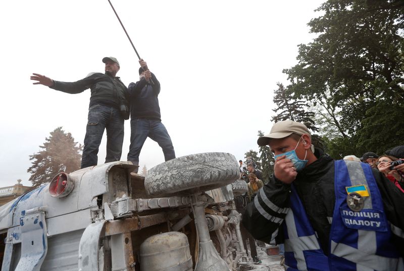 &copy; Reuters. متظاهرون فوق سيارة محطمة في احتجاجات سابقة بالعاصمة الأوكرانية كييف. صورة من أرشيف رويترز
