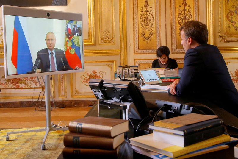 © Reuters. صورة من أرشيف رويترز للرئيس الفرنسي إيمانويل ماكرون في قصر الإليزيه بباريس يتحدث عبر دائرة اتصال مع نظيره الروسي فلاديمير بوتين.