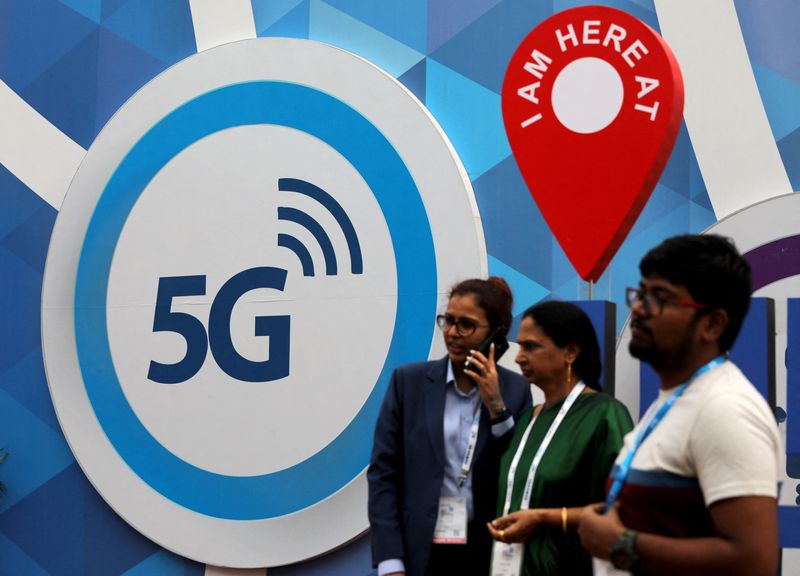 &copy; Reuters. People stand in front of a board depicting 5G network at the India Mobile Congress 2018 in New Delhi, India, October 26, 2018. REUTERS/Anushree Fadnavis