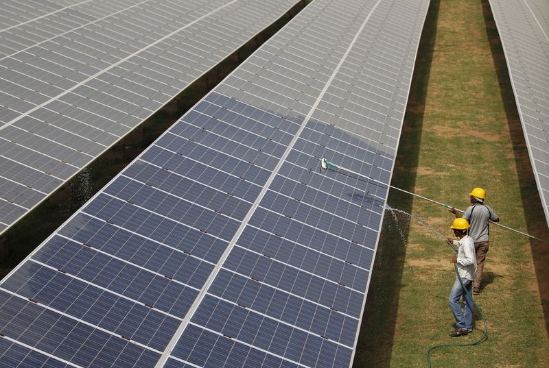 &copy; Reuters. FILE PHOTO: Workers clean photovoltaic panels inside a solar power plant in Gujarat, India, July 2, 2015. REUTERS/Amit Dave