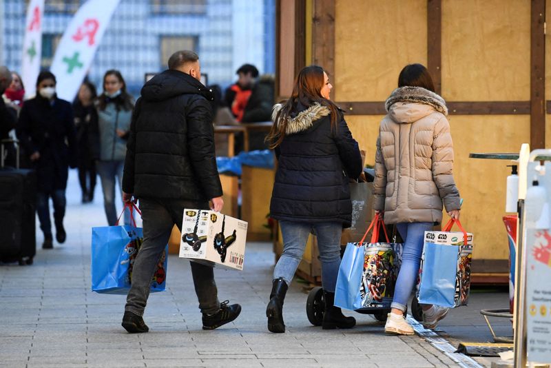 &copy; Reuters. FILE PHOTO: People with shopping bags walk near a shopping center, amid the coronavirus disease (COVID-19) pandemic, in Berlin, Germany December 21, 2021.  REUTERS/Annegret Hilse/File Photo