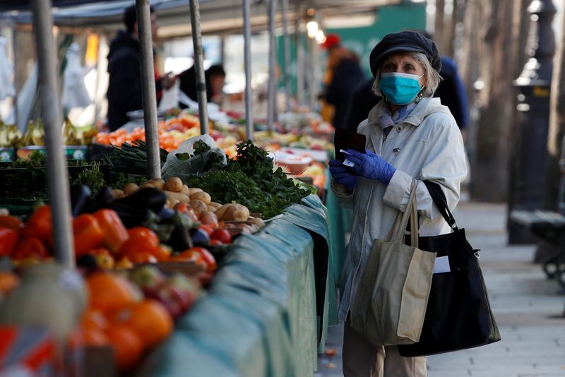 &copy; Reuters. FILE PHOTO: A woman, wearing a protective face mask, shops for fruits and vegetables at the Bastille Market in Paris as a lockdown is imposed to slow the rate of the coronavirus disease (COVID-19) in France, March 19, 2020. REUTERS/Gonzalo Fuentes