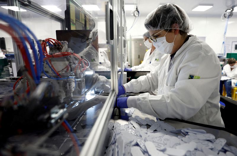 © Reuters. FILE PHOTO: Employees work on the assembly line to produce COVID-19 self-test kits at the NG Biotech factory in Guipry-Messac as France experiences a surge in coronavirus disease (COVID-19) cases due to the Omicron variant, France, January 12, 2022. REUTERS/Stephane Mahe/File Photo