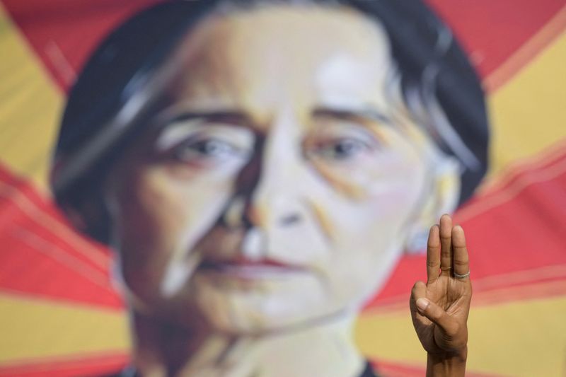 &copy; Reuters. رجل يرفع تحية بثلاثة أصابع أمام صورة لأونج سان سو تشي في يانجون بصورة من أرشيف رويترز.