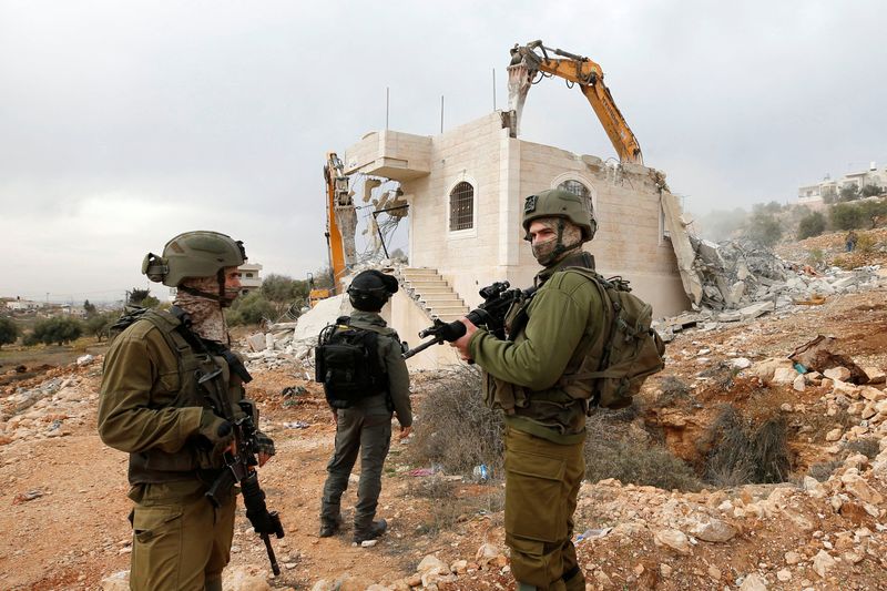 &copy; Reuters. قوات إسرائيلية تشرف على هدم منزل فلسطيني في الخليل بالضفة الغربية يوم 28 ديسمبر كانون الأول 2021. رويترز