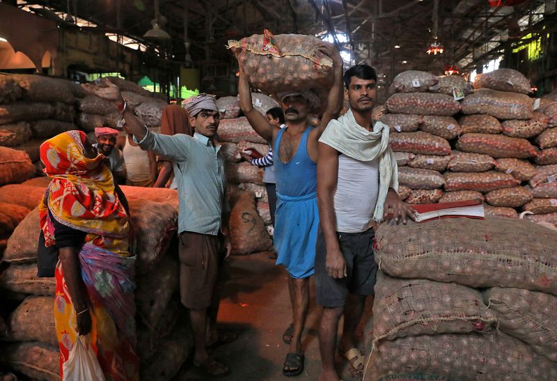 © Reuters. FILE PHOTO: A labourer carries a sack of onions at a wholesale market in Kolkata, India, December 14, 2021. REUTERS/Rupak De Chowdhuri/