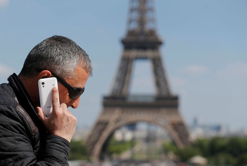 © Reuters. FILE PHOTO: A man makes a phone call using his mobile phone at the Trocadero Square near the Eiffel Tower in Paris, May 16, 2014.  REUTERS/Christian Hartmann