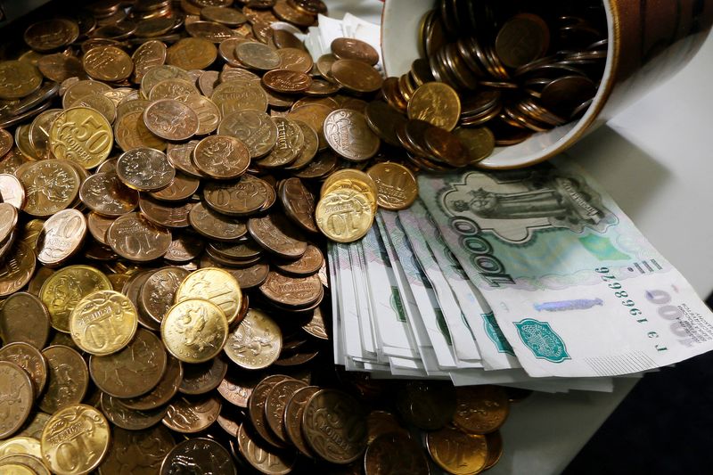 © Reuters. FILE PHOTO: Russian 1000-rouble banknotes, 50 and 10 kopeck coins are seen on a table at a private company's office in Krasnoyarsk, Siberia November 6, 2014.  REUTERS/Ilya Naymushin/File Photo