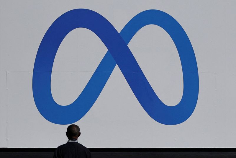 © Reuters. FILE PHOTO: A man stands in front of a sign of Meta, the new name for the company formerly known as Facebook, at its headquarters in Menlo Park, California, U.S. October 28, 2021. REUTERS/Carlos Barria