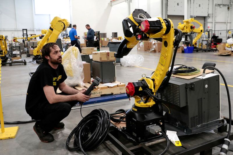 © Reuters. FILE PHOTO: Robot technician Justin McPhail prepares a manufacturing robot for shipping to a customer in a FANUC American facility in Auburn Hills, Michigan, U.S.  August 11, 2021.  Picture taken August 11, 2021.   REUTERS/Rebecca Cook/File Photo