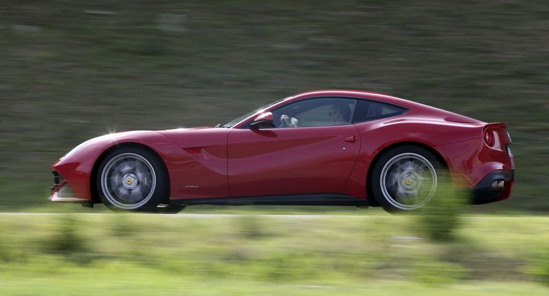 © Reuters. FILE PHOTO: A man drives a Ferrari luxury car in the Ferrari hometown in Maranello, Italy, October 9, 2015.  REUTERS/Stefano Rellandini/File Photo