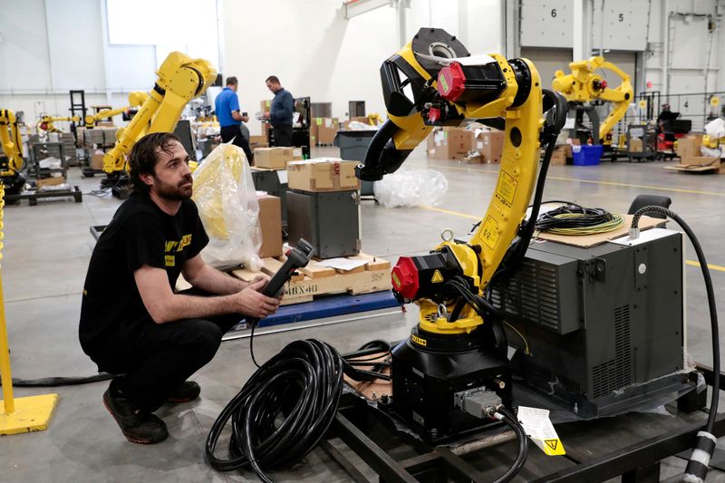 &copy; Reuters. فني الروبوت جوستين ماكفيل يعد روبوتًا صناعيًا لشحنه إلى عميل في منشأة أمريكية بالولايات المتحدة في 11 أغسطس آب 2021. تصوير: ريبيكا كوك - رويترز.