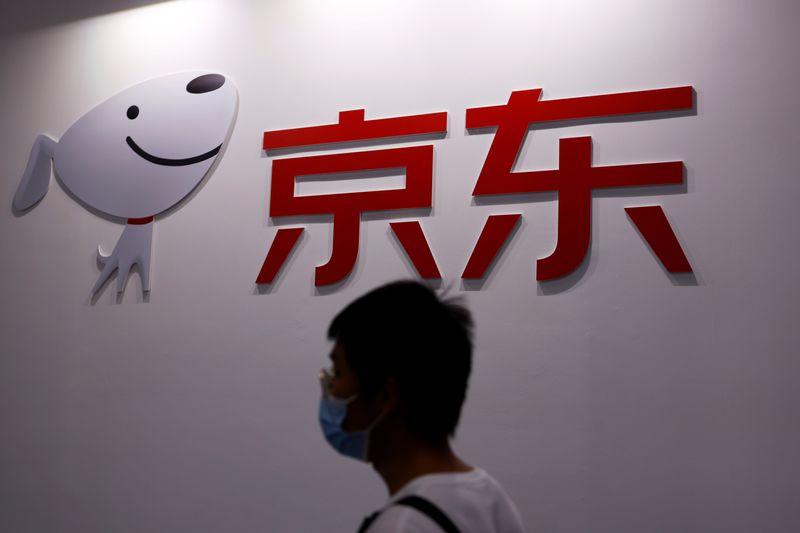 &copy; Reuters. FILE PHOTO: A man walks past the company logo of JD.com during the 2021 China International Fair for Trade in Services (CIFTIS) in Beijing, China September 4, 2021. REUTERS/Florence Lo