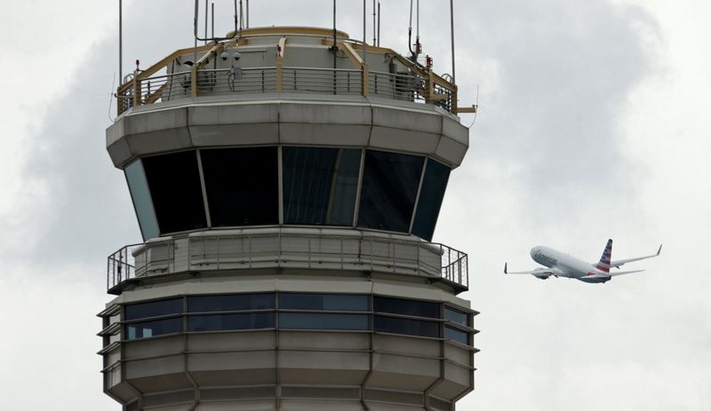 © Reuters. FILE PHOTO: A plane passes the air traffic control tower at Ronald Reagan Washington National Airport in Arlington, Virginia, U.S., June 5, 2017.  REUTERS/Kevin Lamarque