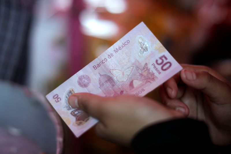 &copy; Reuters. FILE PHOTO: A vendor holds a banknote at an outdoor market in Mexico City, Mexico January 22, 2022. REUTERS/Luis Cortes