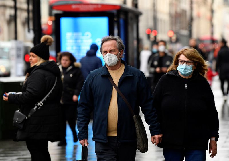 &copy; Reuters. FILE PHOTO: Shoppers wear protective face masks as they walk on Oxford Street, as rules on wearing face coverings in some settings in England are relaxed, amid the spread of the coronavirus disease (COVID-19) pandemic, in London, Britain, January 27, 2022