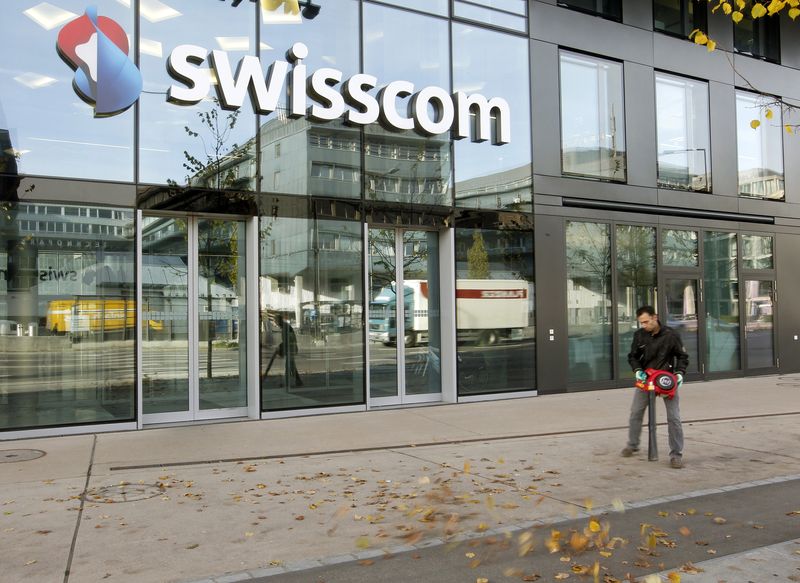 &copy; Reuters. FILE PHOTO: A worker removes foliage from a footpath in front of an office building of Swiss telecom company Swisscom AG in Zurich November 8, 2012.   REUTERS/Arnd Wiegmann 