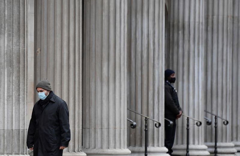 &copy; Reuters. FILE PHOTO: A man wearing a protective face mask walks past the Bank of England (BoE), London, Britain, December 16, 2021. REUTERS/Toby Melville