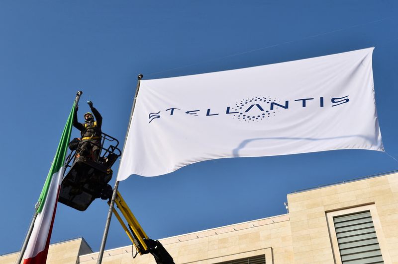 &copy; Reuters. FILE PHOTO: Workers install a flag with the logo of Stellantis, the world's fourth-largest automaker which starts trading in Milan and Paris after Fiat Chrysler and Peugeot maker PSA finalised their merger, at the main entrance of FCA Mirafiori plant in T