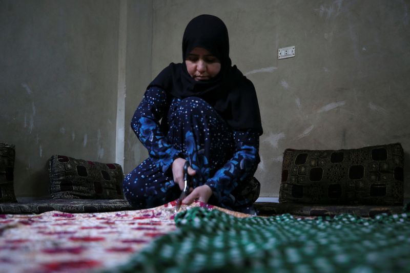 &copy; Reuters. السورية رودا شلاش أثناء عملها في الحياكة بمنزلها قرب دمشق في صورة بتاريخ 18 يناير كانون الثاني 2022. تصوير: يمام الشاعر - رويترز. 