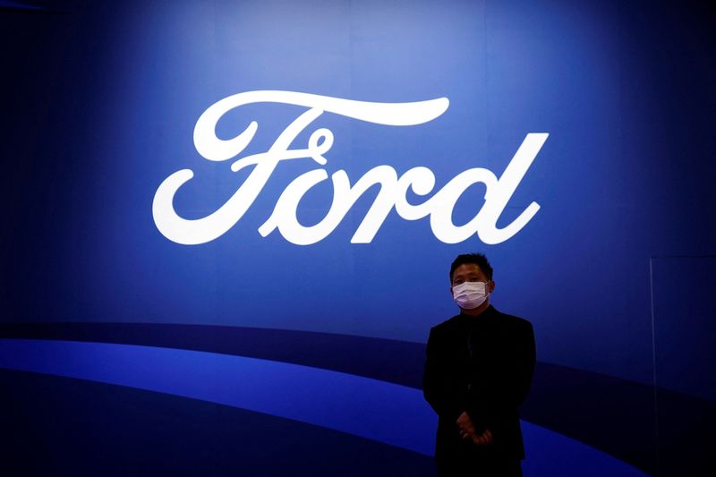&copy; Reuters. FILE PHOTO: A man stands near the Ford logo during a media day for the Auto Shanghai show in Shanghai, China April 19, 2021. REUTERS/Aly Song/File Photo