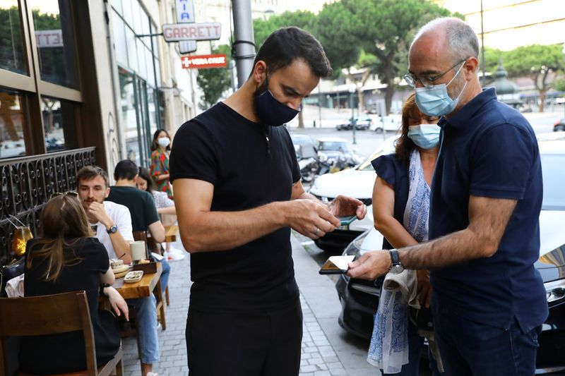 &copy; Reuters. FOTO DE ARCHIVO: Un trabajador de un restaurante comprueba el certificado de vacunación contra el COVID-19 de un hombre en Oporto, Portugal, el 10 de julio de 2021. REUTERS/Violeta Santos Moura