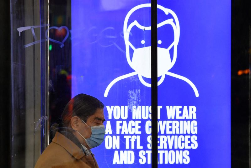 &copy; Reuters. FILE PHOTO: A person wearing a protective face mask waits at a bus stop, as rules on wearing face coverings in some settings in England are relaxed, amid the spread of the coronavirus disease (COVID-19) pandemic, in London, Britain, January 27, 2022. REUT