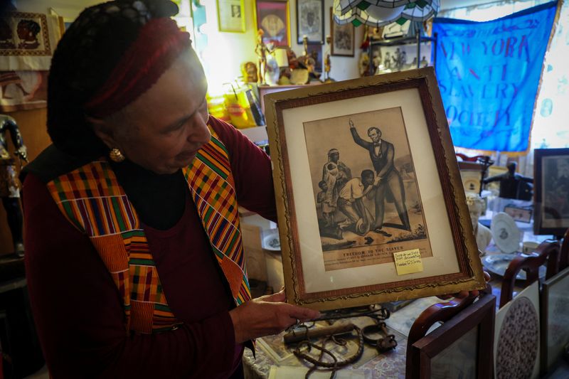 &copy; Reuters. Elizabeth Meaders, de 90 anos, segura uma gravura de Currier e Ives documentando a liberdade sendo dada a escravos, em meio a sua coleção de milhares de artefatos históricos e culturais que traçam a experiência afro-americana
02/02/2022
REUTERS/Mike 