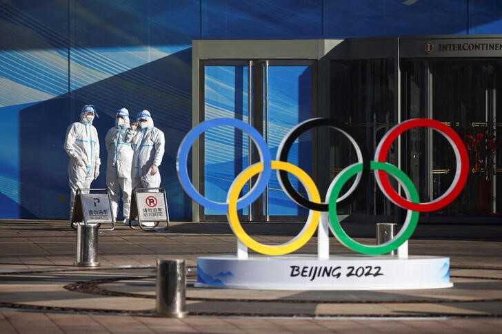 &copy; Reuters. Workers in PPE stand next to the Olympic rings inside the closed loop area near the National Stadium, or the Bird's Nest, where the opening and closing ceremonies of Beijing 2022 Winter Olympics will be held, in Beijing, China December 30, 2021. REUTERS/T