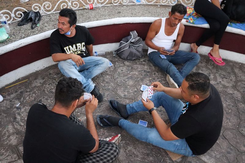 &copy; Reuters. Migrants play cards as they gather at Benito Juarez square in Tapachula, Mexico February 5, 2022. REUTERS/Jose Torres