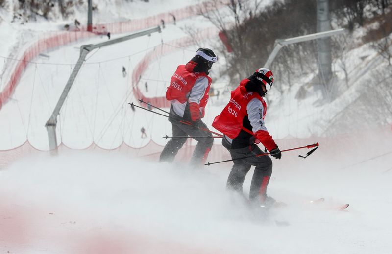 &copy; Reuters. 　北京冬季五輪は６日、アルペンスキー男子滑降を行う予定だったが、強風のためこの日の競技は延期となった。写真はスロープをチェックする五輪スタッフ（２０２２年　ロイター）