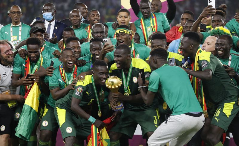 © Reuters. السنغالي كاليدو كوليبالي يرفع كأس بطولة الأمم الأفريقية لكرة القدم في ياوندي يوم الأحد. تصوير: محمد عبد الغني - رويترز