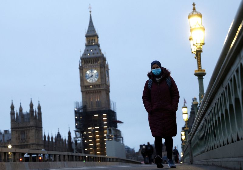 &copy; Reuters. FOTO DE ARCHIO: Una persona con mascarilla cruza el puente de Westminster en Londres, Reino Unido, el 27 de enero de 2022. REUTERS/John Sibley