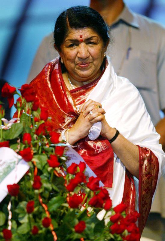 &copy; Reuters. La cantante de Bollywood Lata Mangeshkar mira un ramo que recibió en su 75 cumpleaños durante una celebración en Bombay Septiembre
28 de enero de 2003. REUTERS/Sherwin Crasto/Foto de archivo