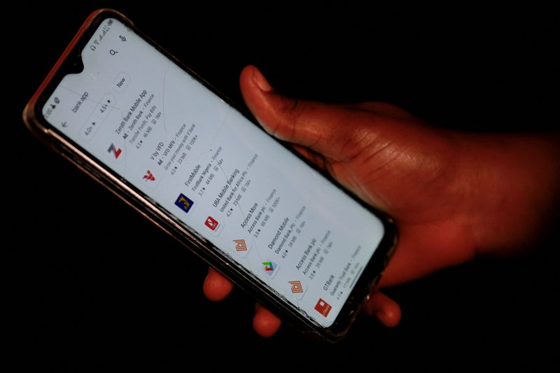 &copy; Reuters. FILE PHOTO: A woman shows a screen of her smartphone, where Access bank mobile app is seen among others, in Abuja, Nigeria September 21, 2020. Picture taken September 21, 2020. REUTERS/Afolabi Sotunde/File Photo