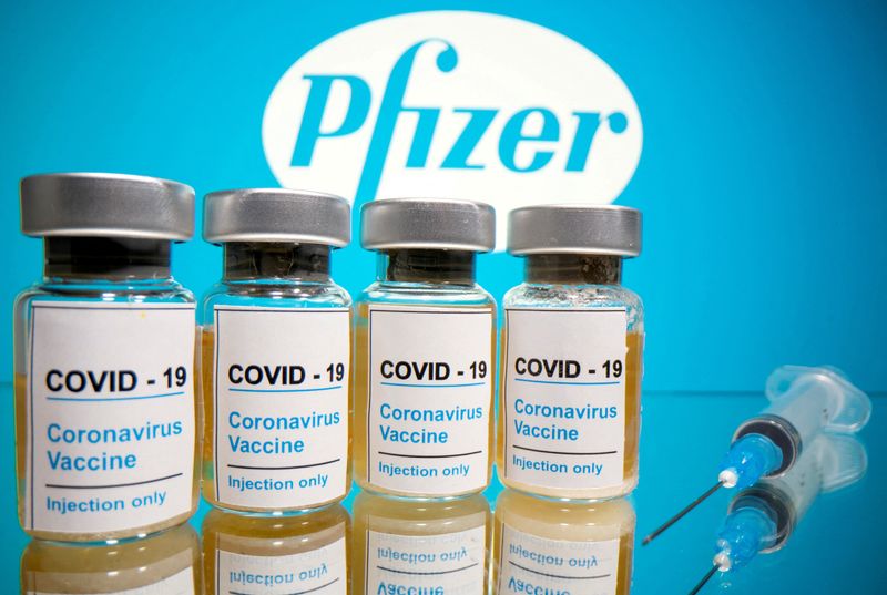 &copy; Reuters. FILE PHOTO: Vials with a sticker reading, "COVID-19 / Coronavirus vaccine / Injection only" and a medical syringe are seen in front of a displayed Pfizer logo in this illustration taken October 31, 2020. REUTERS/Dado Ruvic/Illustration