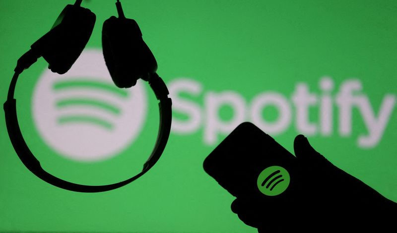 &copy; Reuters. FILE PHOTO: A smartphone and a headset are seen in front of a screen projection of Spotify logo, in this picture illustration taken April 1, 2018. REUTERS/Dado Ruvic/Illustration