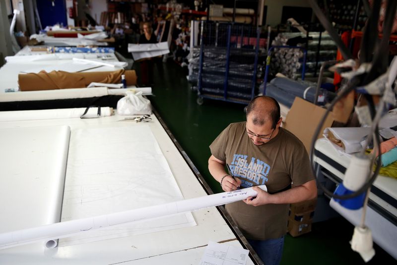 &copy; Reuters. FILE PHOTO: People work in a textile factory in Madrid, Spain May 19, 2014. REUTERS/Andrea Comas