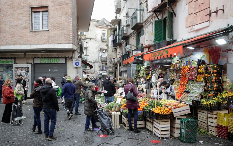 &copy; Reuters. FILE PHOTO: People wear protective face masks as they shop at market, on the fourth day of an unprecedented lockdown across of all Italy imposed to slow the outbreak of coronavirus, in Naples, Italy March 13, 2020. REUTERS/Ciro de Luca