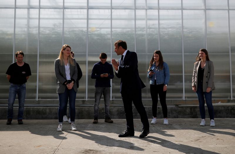 &copy; Reuters. FILE PHOTO: French President Emmanuel Macron waves to farmers and workers as he visits the Roue farm in Cleder during a day trip centered on agriculture amid the coronavirus disease (COVID-19) outbreak in Brittany, France, April 22, 2020. REUTERS/Stephane