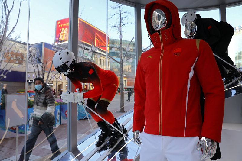 &copy; Reuters. A man walks past an Anta pop-up booth displaying the company's design for the Chinese national team during the Beijing 2022 Winter Olympics, on a shopping street in Beijing, China January 25, 2022. Picture taken January 25, 2022. REUTERS/Tingshu Wang