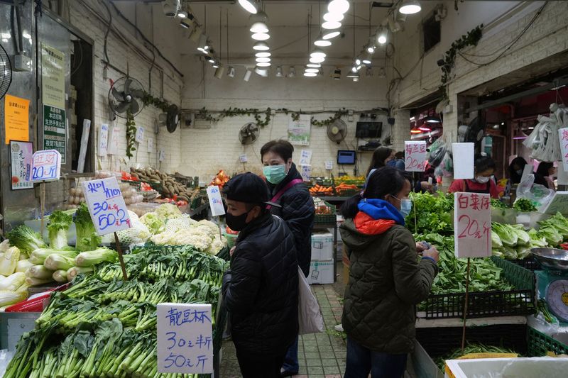 &copy; Reuters. Clientes con mascarillas compran verduras en un mercado en Tsuen Wan, luego del brote de la enfermedad coronavirus (COVID-19) en Hong Kong, China, el 8 de febrero de 2022. REUTERS/Lam Yik