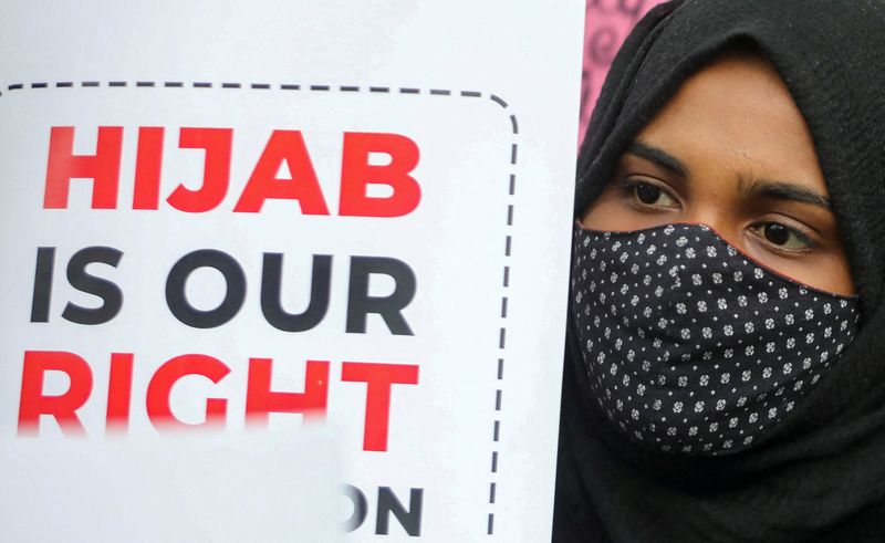 &copy; Reuters. طالبة مسلمة تحمل لافتة خلال احتجاج على حظر الحجاب في مدارس بولاية كارناتاكا في نيودلهي يوم الثلاثاء. تصوير: أنوشري فادنافيس - رويترز
