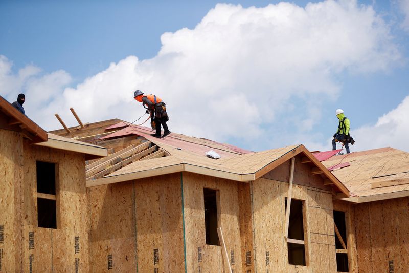 © Reuters. FILE PHOTO: Carpenters work on building new townhomes that are still under construction while building material supplies are in high demand in Tampa, Florida, U.S., May 5, 2021.  REUTERS/Octavio Jones