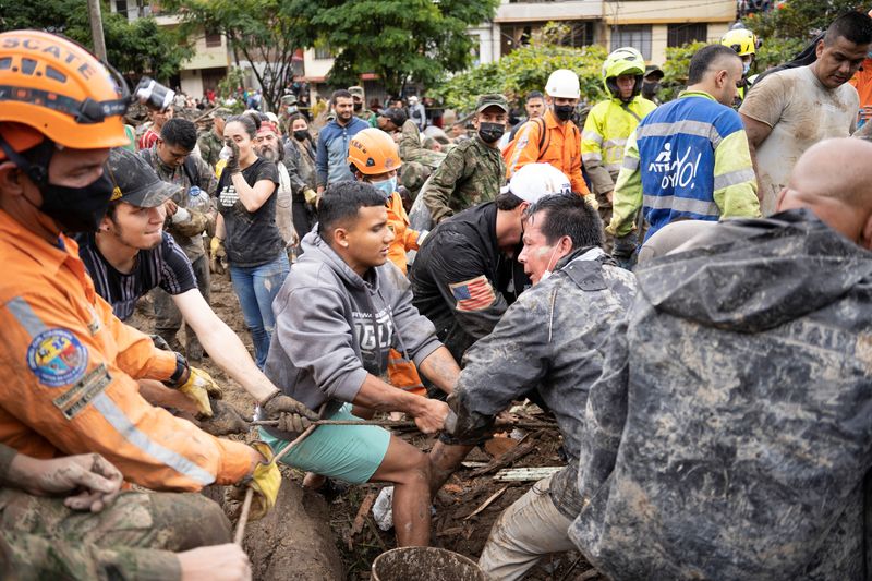 &copy; Reuters. أناس يرفعون أنقاضا بعد انهيار أرضي في أعقاب هطول أمطار غزيرة بالقرب من مدينة بيريرا في كولومبيا يوم الثلاثاء. تصوير: رويترز.