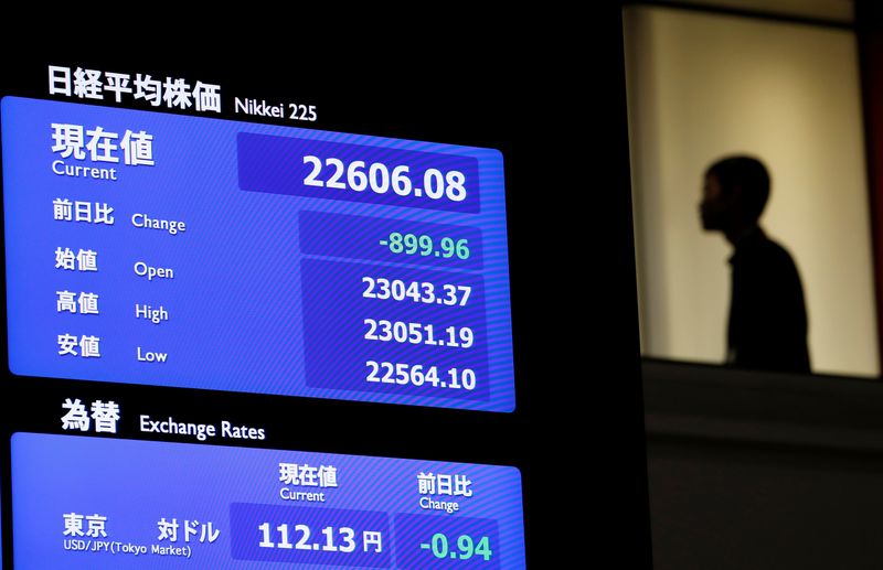 &copy; Reuters. FILE PHOTO: A man is seen behind an electronic board displaying the Nikkei average and Japanese yen rate againt the U.S. dollar at the Tokyo Stock Exchange in Tokyo, Japan, October 11, 2018. REUTERS/Issei Kato